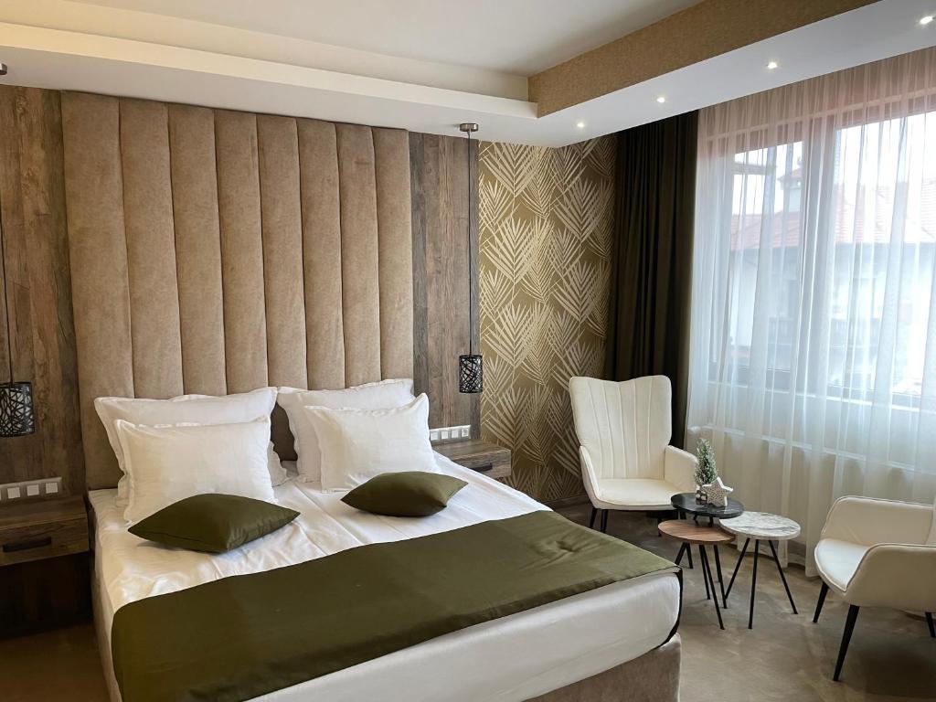 西格伏沙尔克Paradise SPA Hotel的一间卧室配有一张大床和一把椅子