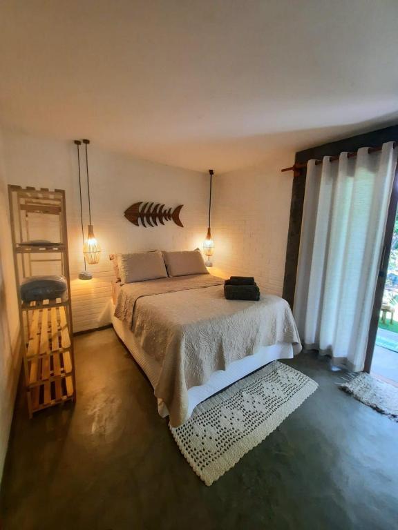 马劳Estudio Lirios seu cantinho ecológico na natureza的一间卧室设有一张床和一个大窗户
