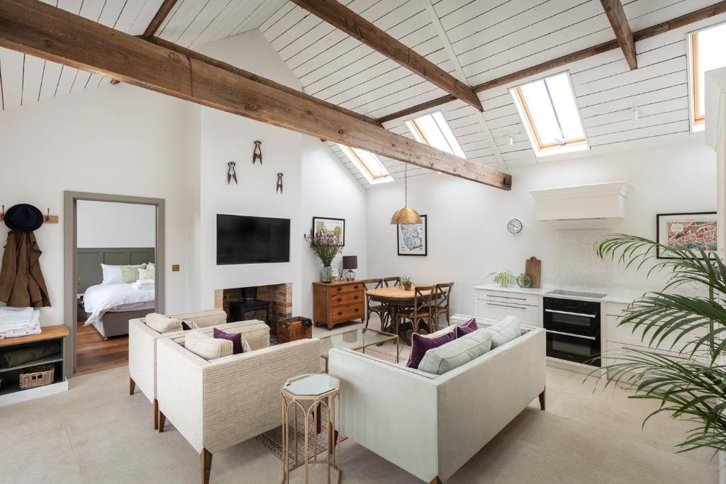 斯坦福德Linseed Barn- Stamford Holiday Cottages的一间客厅,配有白色家具和一间卧室