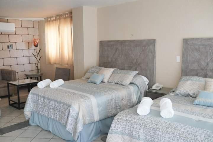 Iguala de la IndependenciaHOTEL MARIA ISABEL DE IGUALA的一间卧室配有两张带毛巾的床