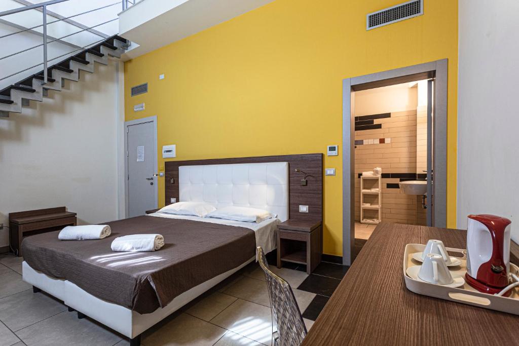 阿沃拉唐乔万尼酒店的一间卧室配有一张床铺和一张桌子,还有一间浴室