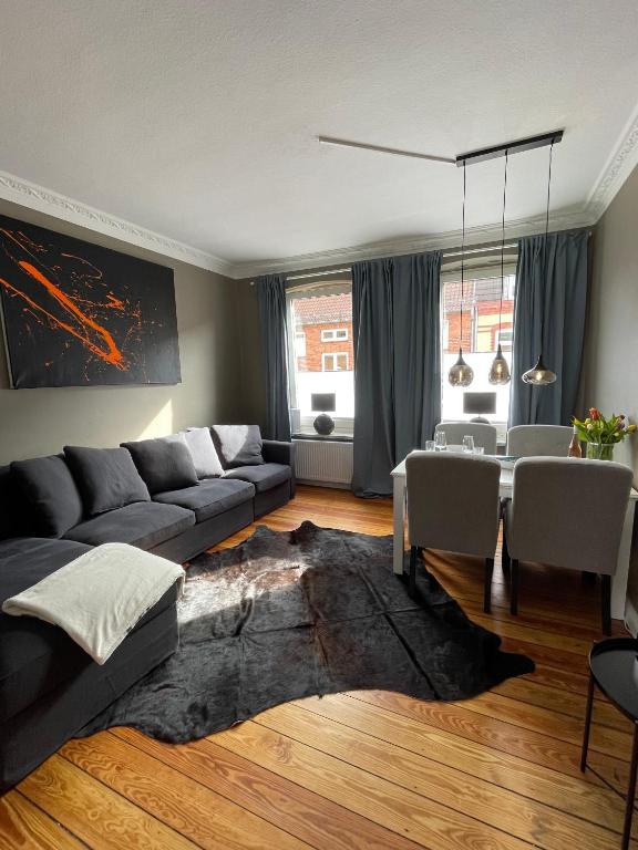 基尔Altbaucharme Deluxe mit Balkon in zentraler Lage的客厅配有沙发和桌子