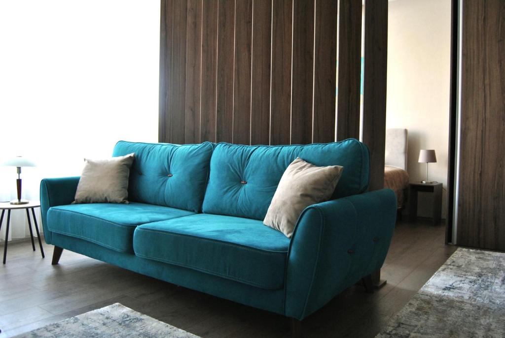 新帕扎尔Apartmani SOVA的客厅里一张蓝色的沙发