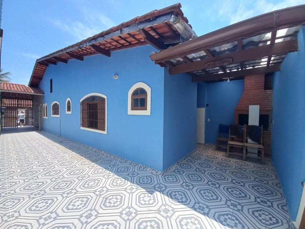蒙加瓜Casa em Mongaguá Plataforma的蓝色房屋,设有瓷砖地板和屋顶