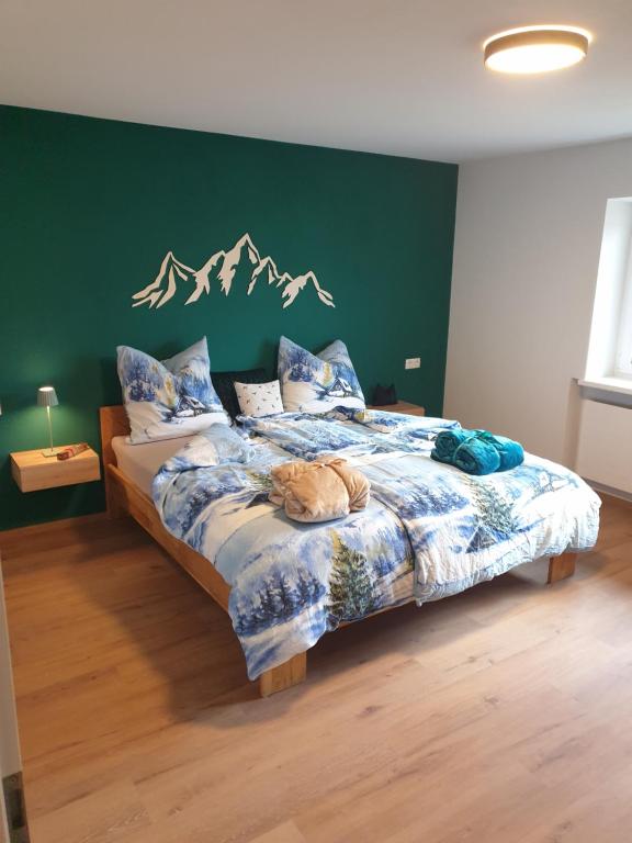 BreitenwangPanoramablick的一间卧室配有一张带绿色墙壁的床