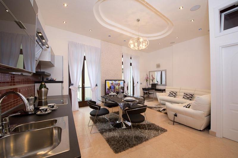 阿科阿科豪华公寓式酒店的厨房以及带桌子和沙发的客厅。