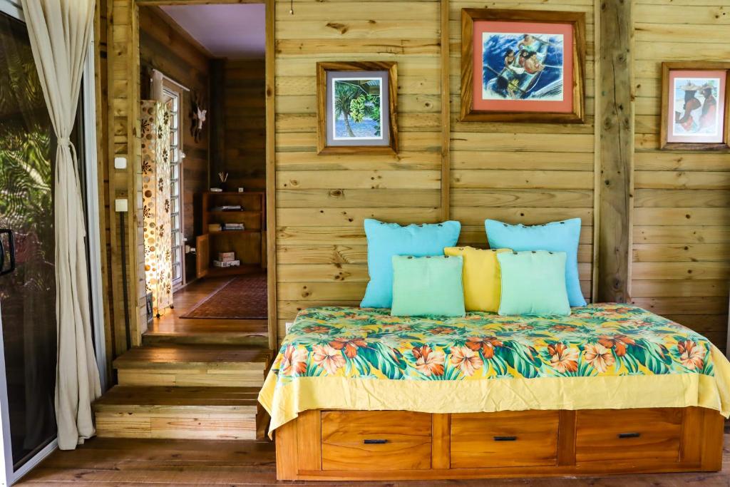 法勒Bungalow Bali Hai的一间卧室配有蓝色和黄色枕头的床