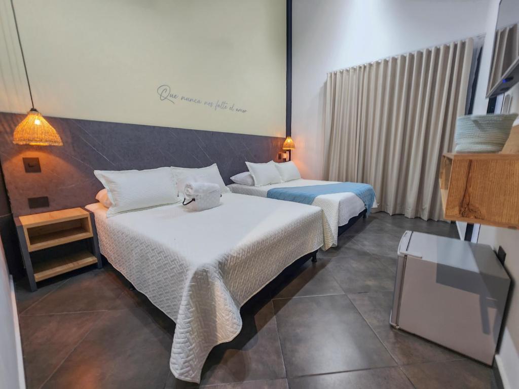 多拉代尔Hotel Capri Doradal的配有电视的酒店客房内的两张床