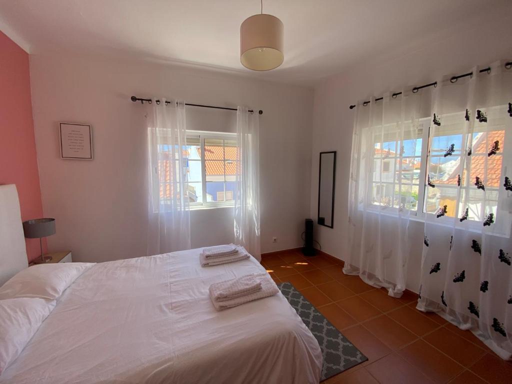米尔芳提斯城Apartamento Vicentino的卧室配有白色的床和2扇窗户。