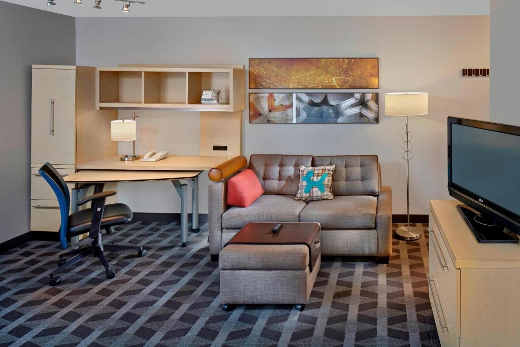 奥尔巴尼奥尔巴尼万豪唐普雷斯酒店/医疗中心的客厅配有沙发、桌子和书桌