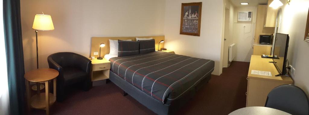 库马库马汽车旅馆的小酒店客房配有一张床和一张书桌