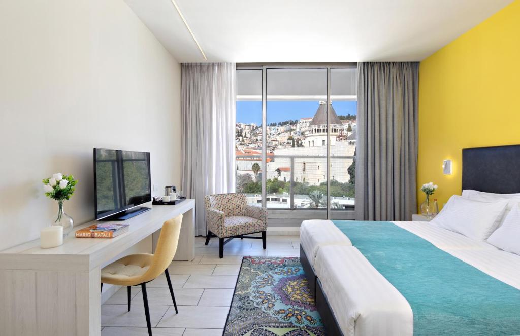 拿撒勒拿撒勒会议中心酒店的配有一张床、一张书桌和一扇窗户的酒店客房