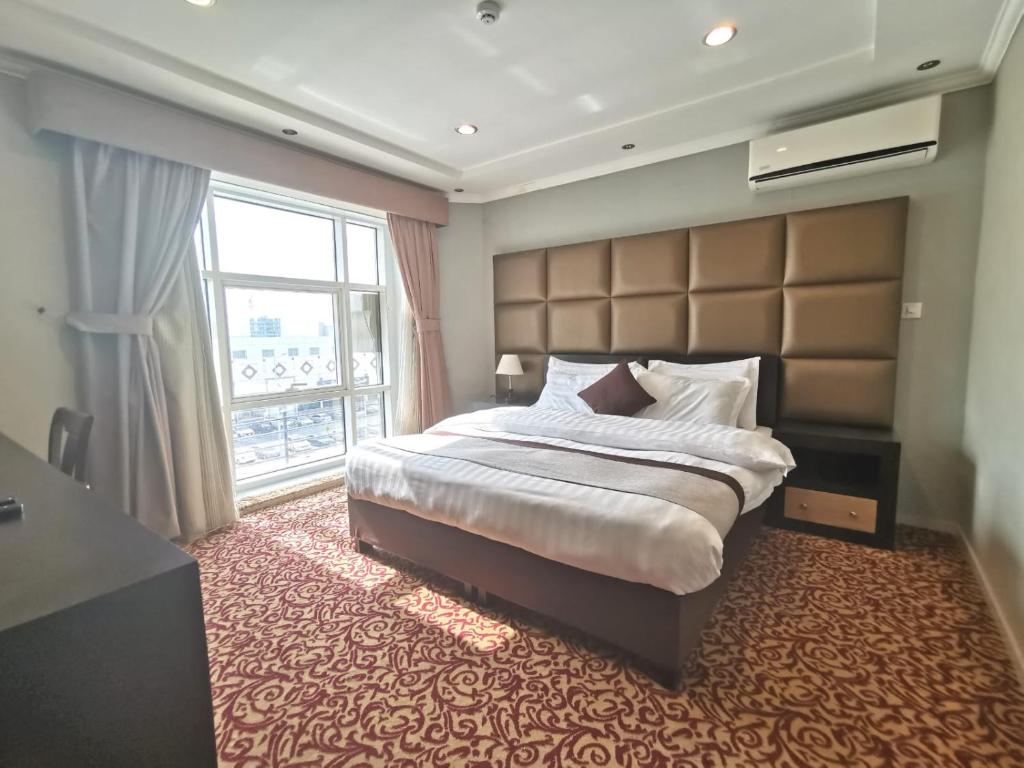 利雅德阿施伯恩套房酒店的一间卧室设有一张大床和一个大窗户