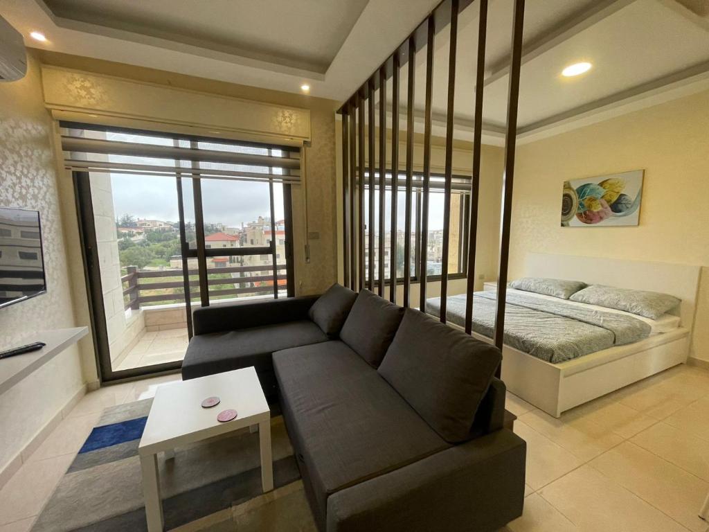 安曼Jubeiha View Apartments的客厅配有沙发和1张床