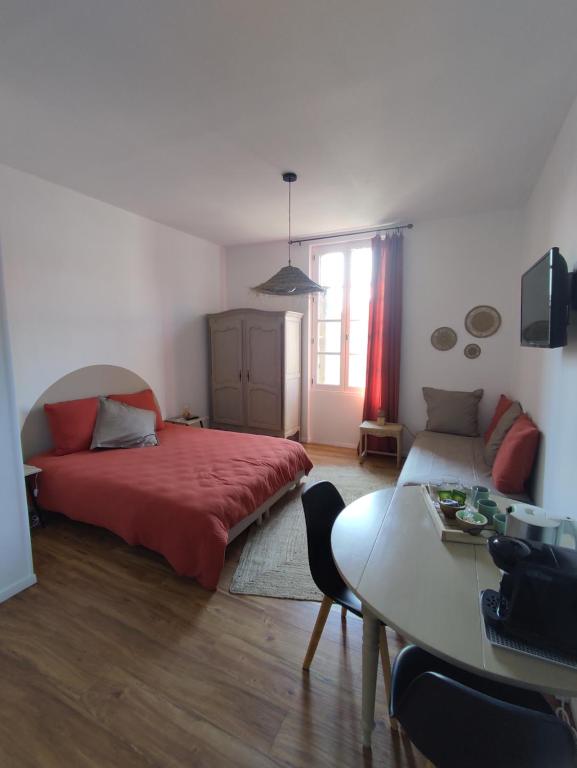 蒙特利马尔La Provinciale en Ville的一间卧室配有红色的床和一张桌子