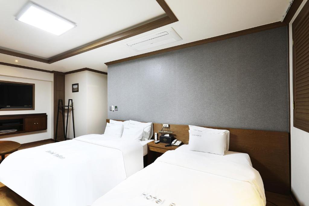 光州BOLTON Hotel的一间酒店客房,设有两张床和电视