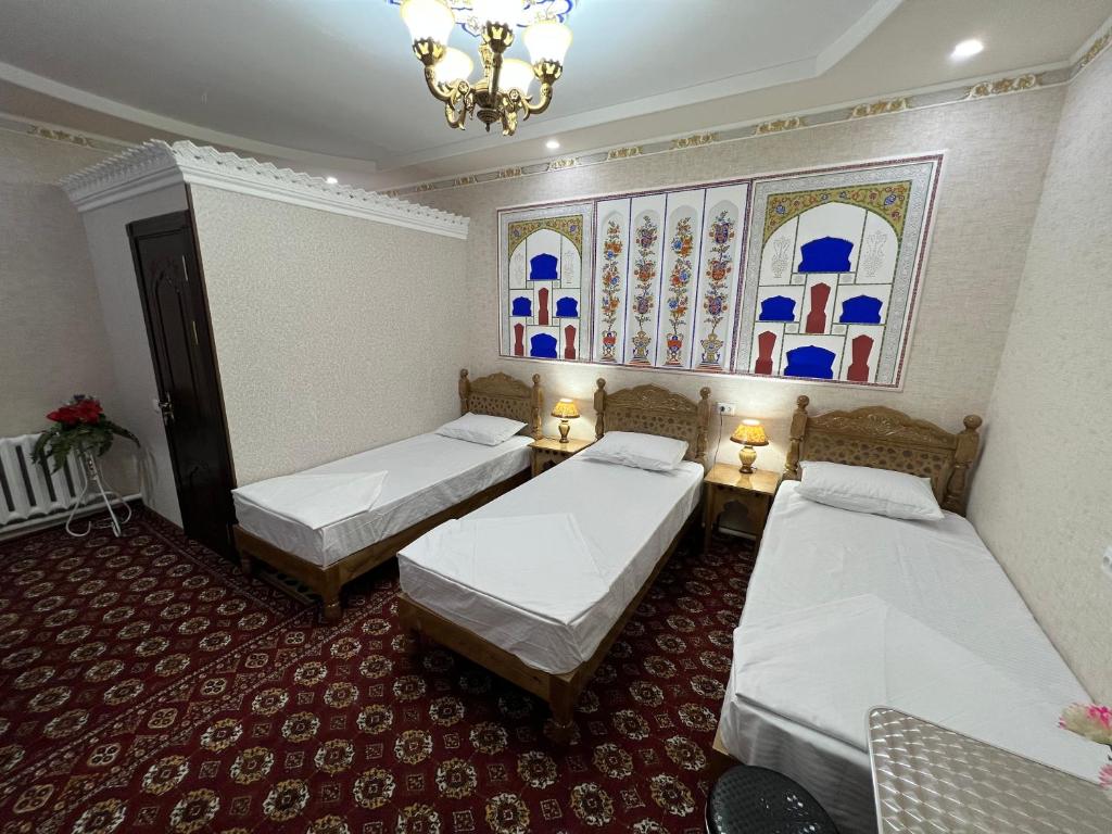 布哈拉''NAVO'' Guest House的带三张床和吊灯的客房
