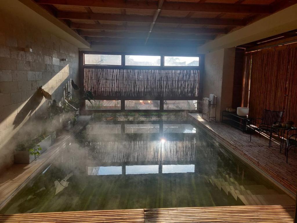 MerhavyāhSera Suites的一个带大窗户的房间内的游泳池