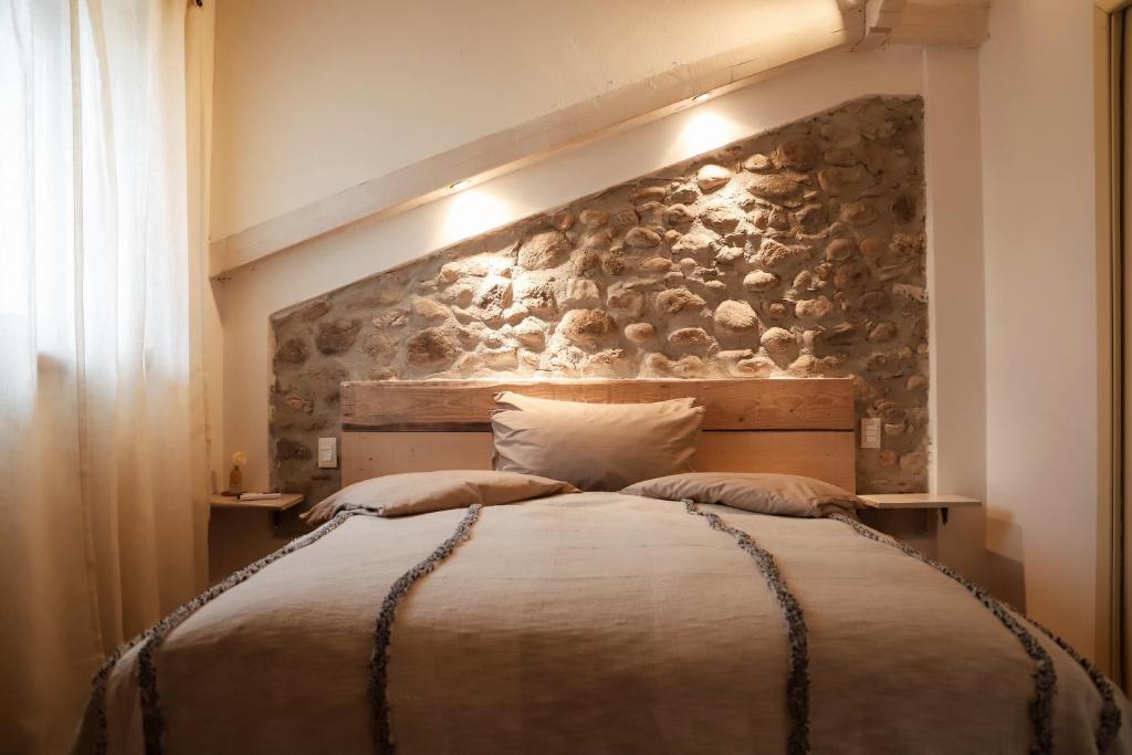 Rivoli VeroneseCà Nova B&B的一间卧室设有一张带石墙的大床