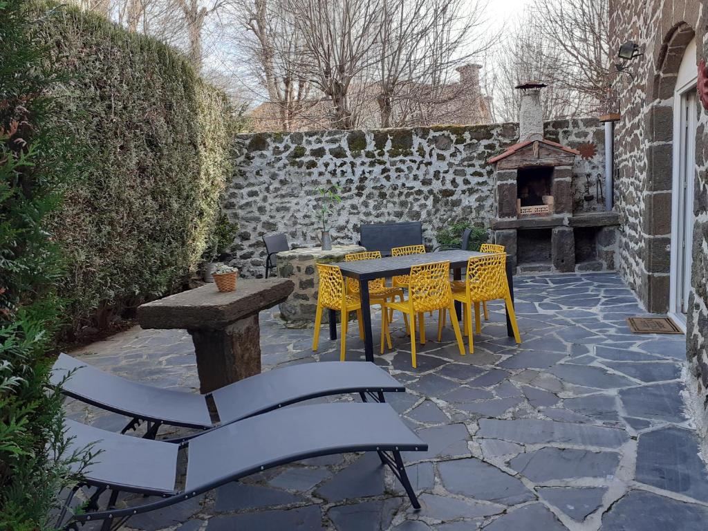 PolignacMaison du Soleil chez Isa的庭院配有桌椅和壁炉。