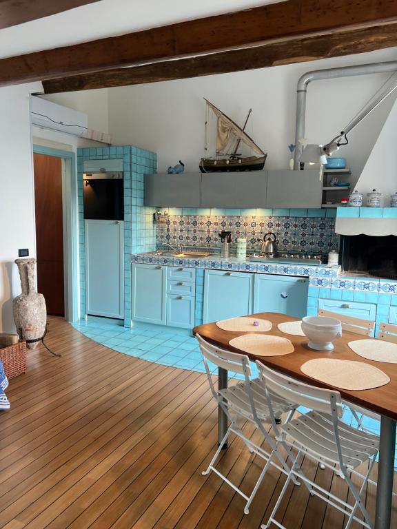 蒙特罗索阿尔马雷Elegant apartment with sea view的厨房铺有木地板,配有蓝色橱柜。
