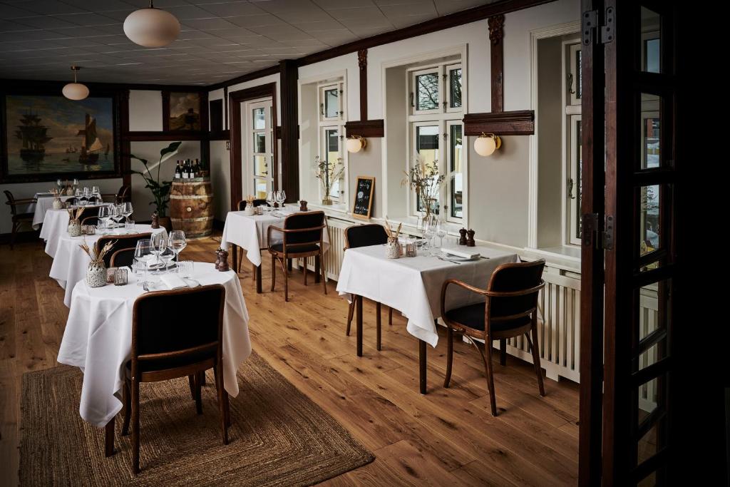 斯卡恩斯卡恩斯特兰德里酒店的餐厅配有桌椅和白色桌布