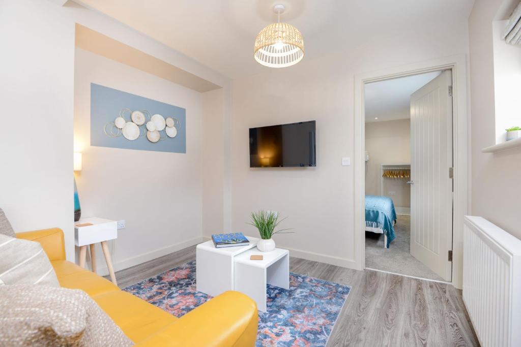 普里茅斯Apartment One - King Bed - Free Private Parking - by Ocean City Retreats的客厅设有黄色沙发和电视