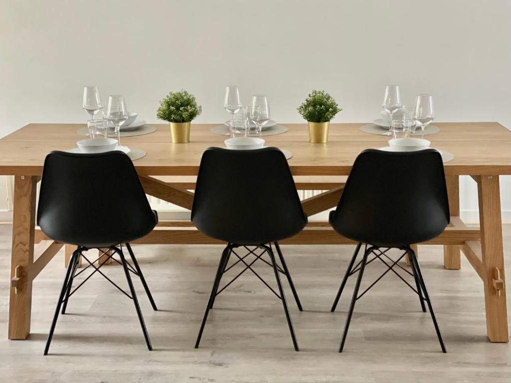 马塞克Sfeer的一张木桌,四周摆放着三把黑色椅子