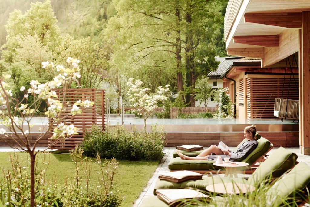 齐勒河谷采尔MalisGarten Green Spa Hotel的坐在花园沙发上的女人