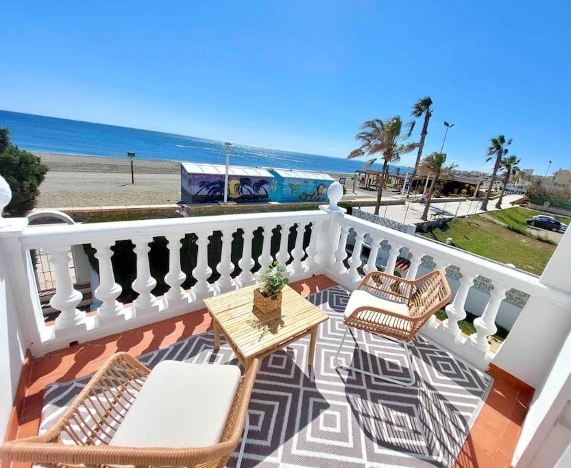 托雷德尔马尔Caleta Beach House Villa Beatriz Sinese Design的一个带桌椅和海滩的阳台