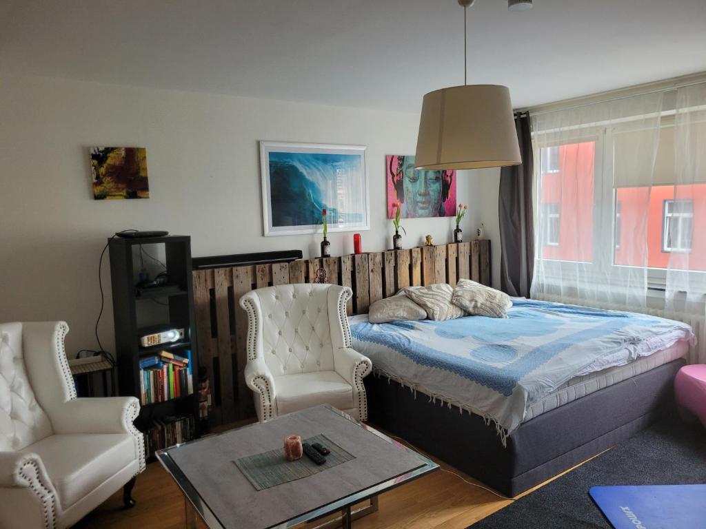 科隆1 Zimmer App in Köln Ehrenfeld的一间卧室配有一张床、一把椅子和一张桌子