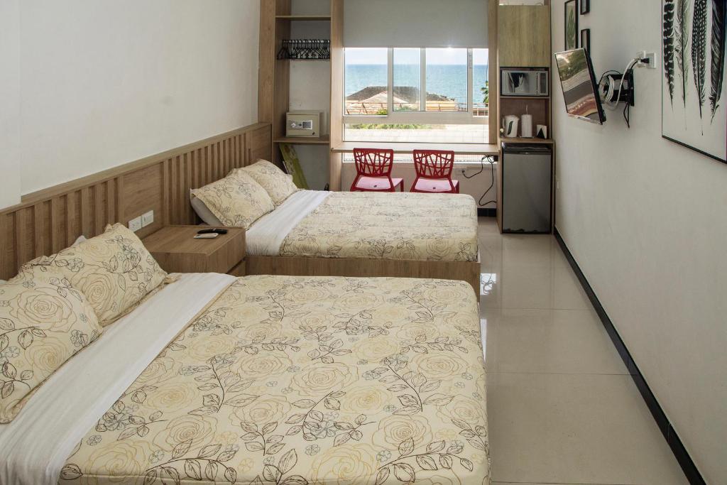 卡塔赫纳Apartamento Ganem 505a的一间带两张床的卧室和一间带两把椅子的厨房