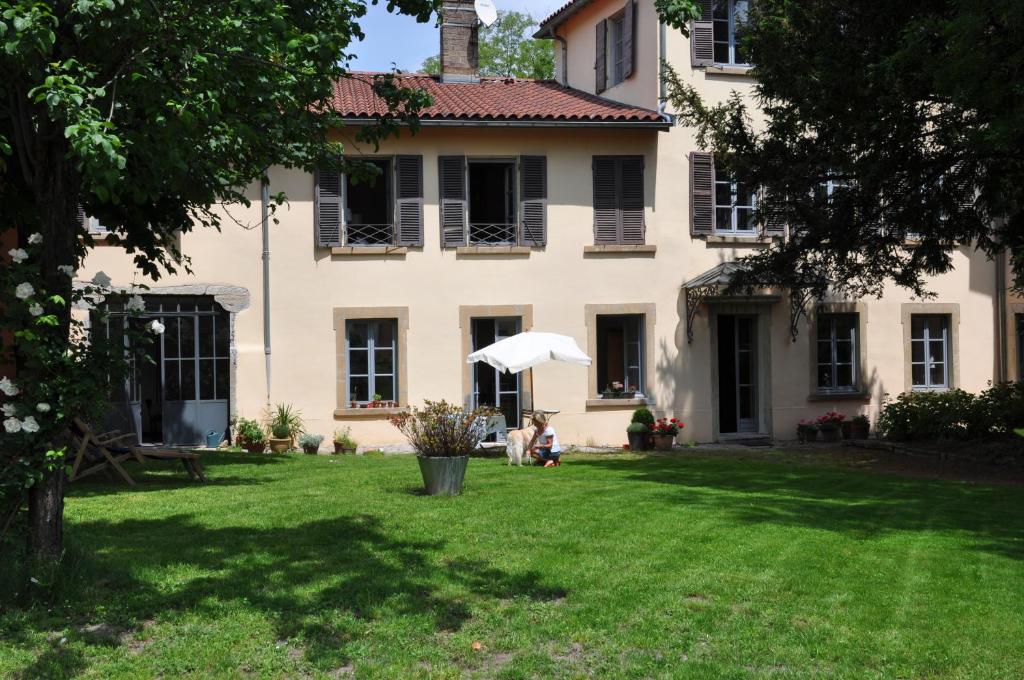 里昂博瓦尔花园酒店的坐在房子院子的伞下的人