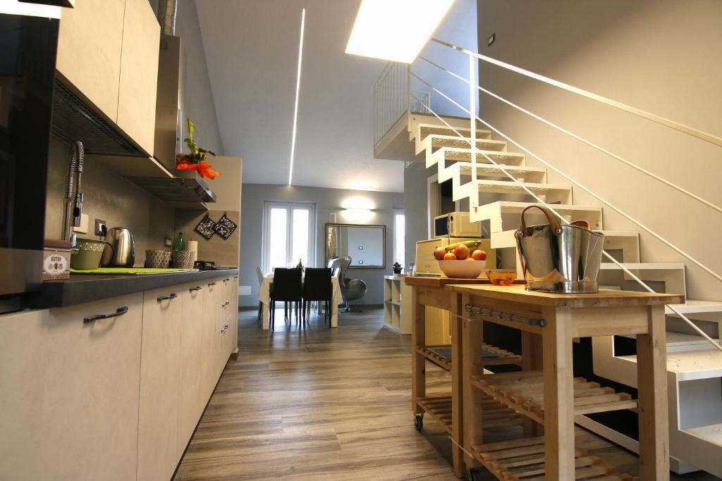 格拉齐Il Profumo Dellegrazie的一间设有楼梯和桌子的厨房