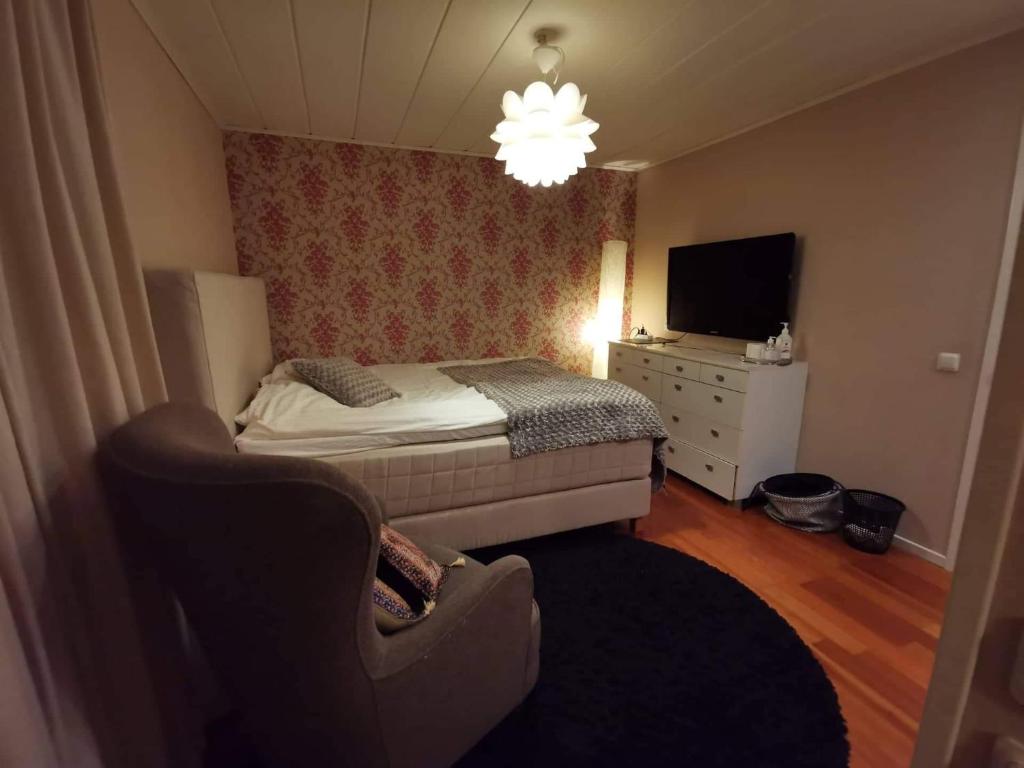 吕勒奥OWN ROOM WITH BIG BED IN A BIG HOUSE!的一间卧室配有一张床、一把椅子和电视