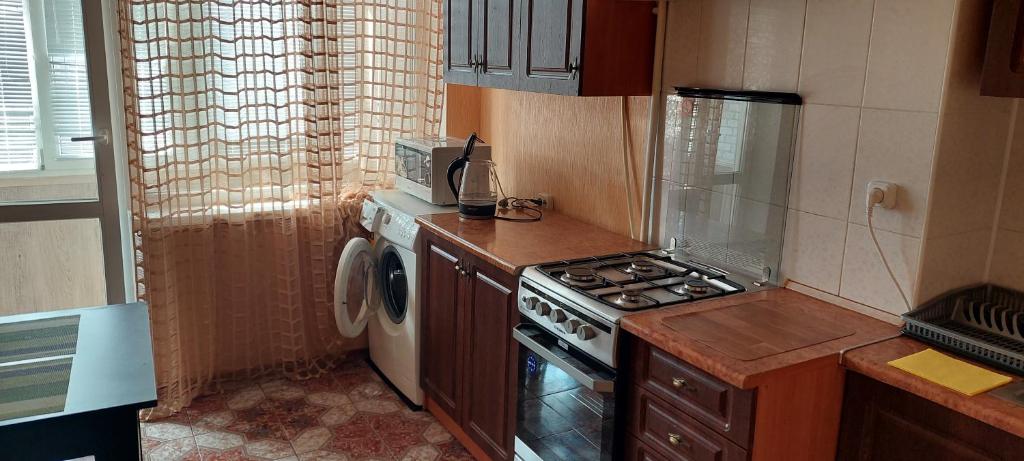 尼古拉耶夫Центр 3 слободская的厨房配有炉灶和洗衣机。