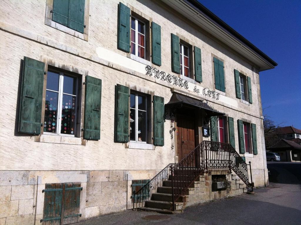 BallaiguesChambres d'hôtes Chez Epicure的一座带绿色百叶窗和门的古老建筑