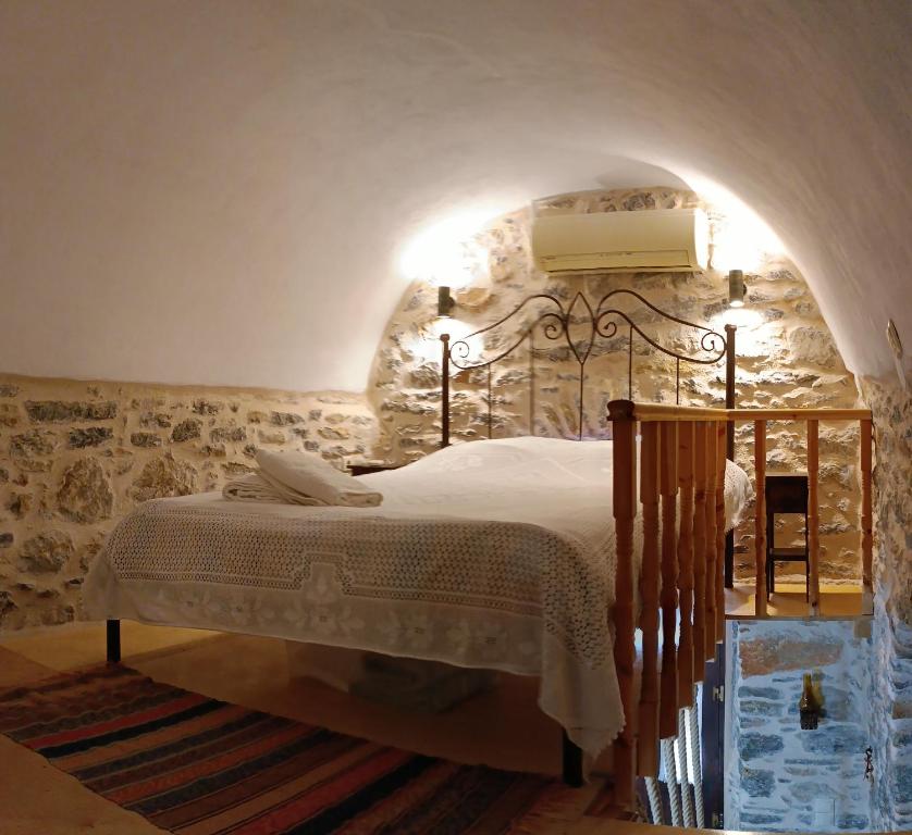梅斯塔ΜΕΣΤΑ - ΠΛΑΤΕΙΑ的卧室配有一张石墙床