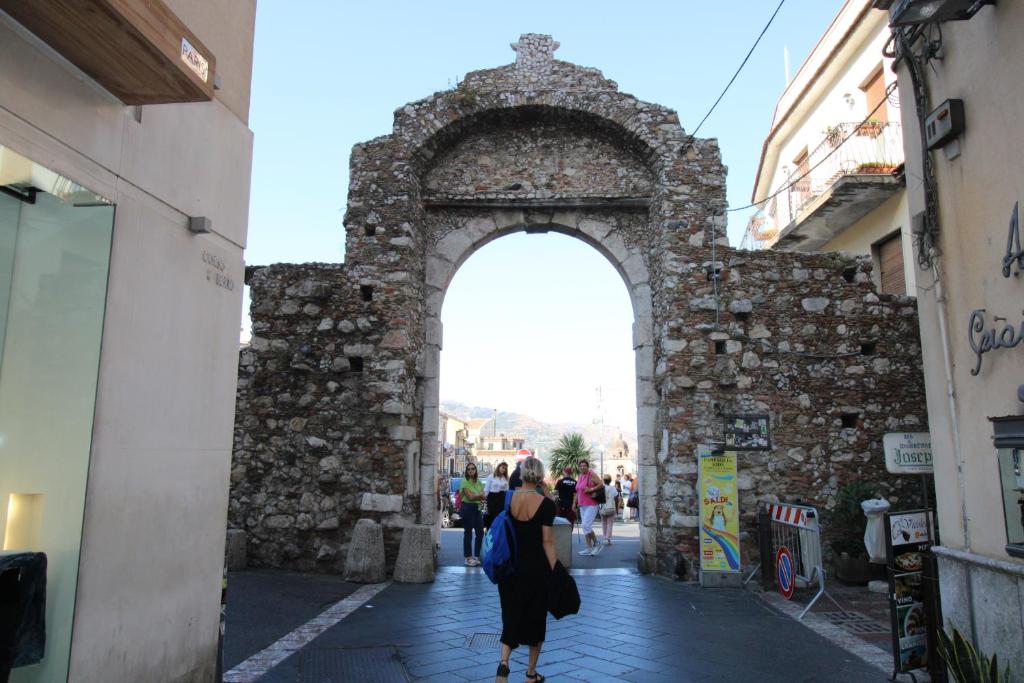 陶尔米纳C’est la vie TAORMINA的一条在街上走过石拱门的女人