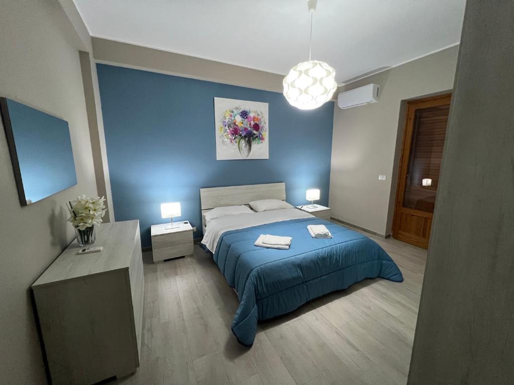 马斯卡利Casa vacanza Tropicana Home的一间卧室设有一张床和蓝色的墙壁