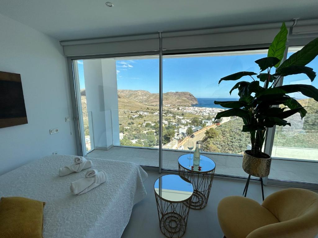 拉斯内格拉斯Samarkanda Apartamento- Suite con espectacular vista panorámica的一间卧室设有大窗户,配有一张床和植物