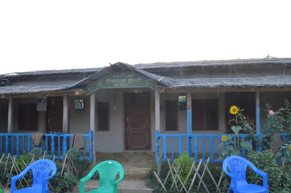 Bhada Community Homestay的前面有蓝色椅子的房子
