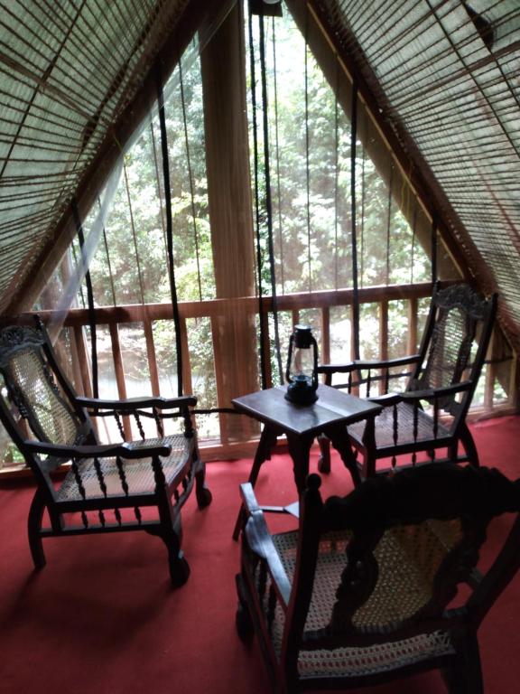 RattotaRiverston Du Eco Cottage的窗户前设有2把椅子和1张桌子的房间