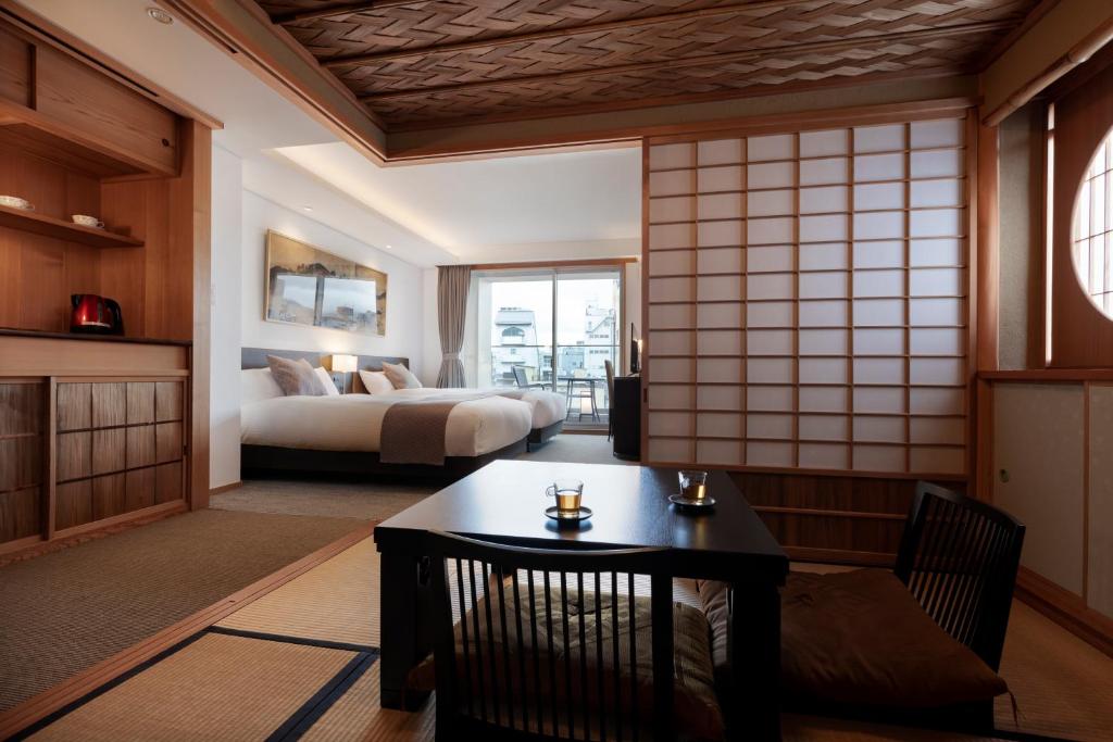 京都Rinn Gion Hanatouro的一间客房内配有床和桌子的房间