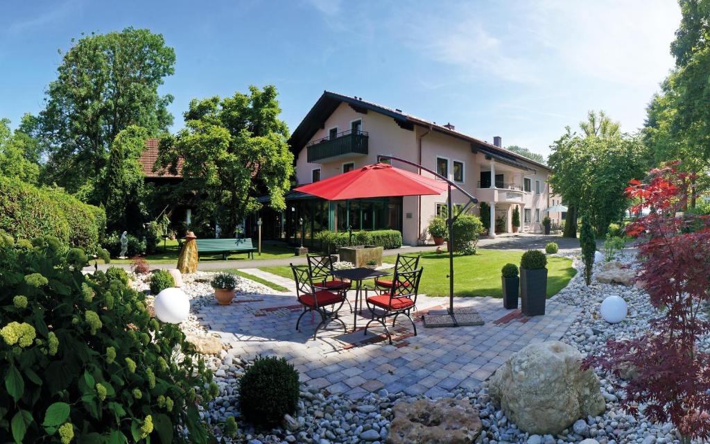 巴特法兴格Landhaus Riedl的庭院配有椅子和一张桌子及红伞