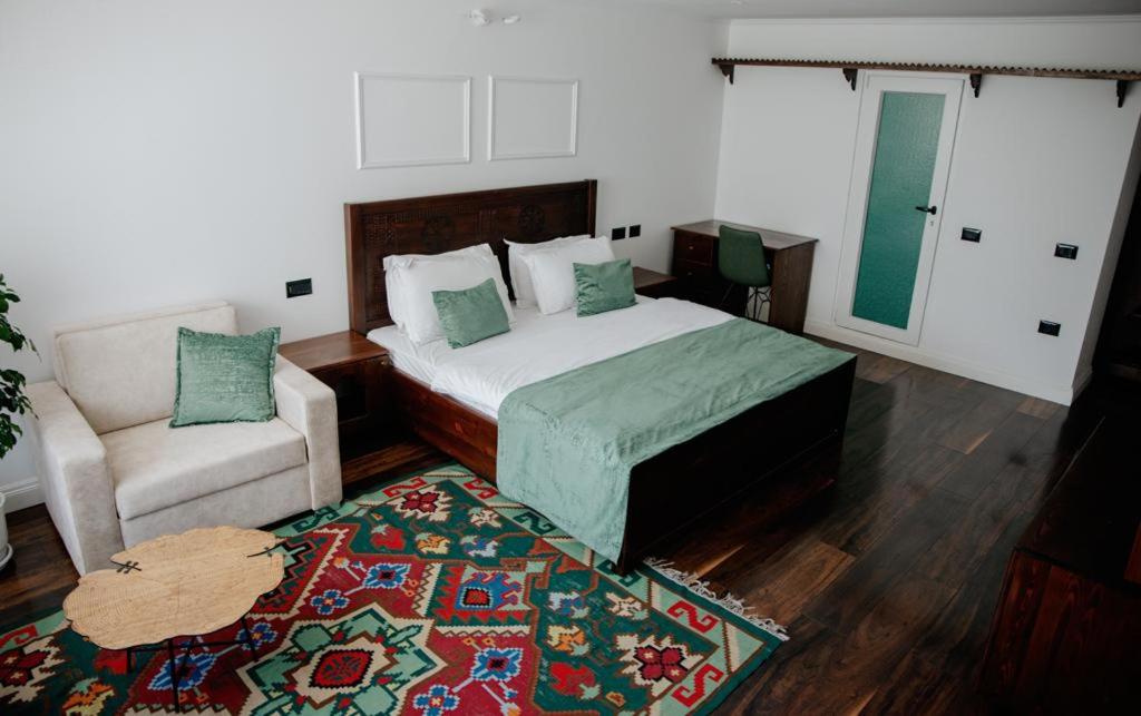 泰斯Hotel Thethi的一间卧室配有一张床、一把椅子和地毯