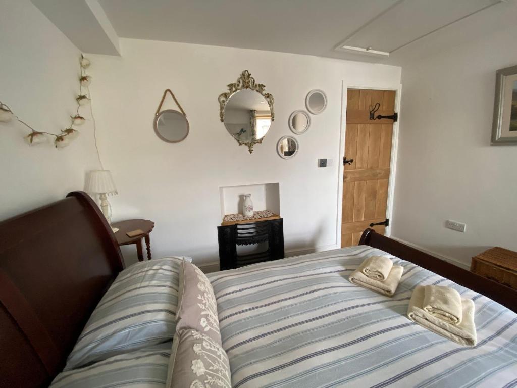 塞特尔Dugdales Cottage的一间卧室配有一张床,上面有两条毛巾