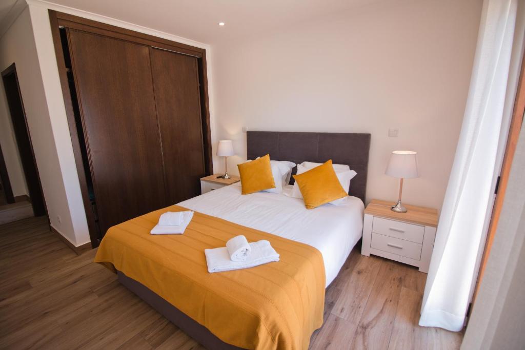 拉戈斯Casa da Ladeira Branca的一间卧室配有一张床,上面有两条毛巾