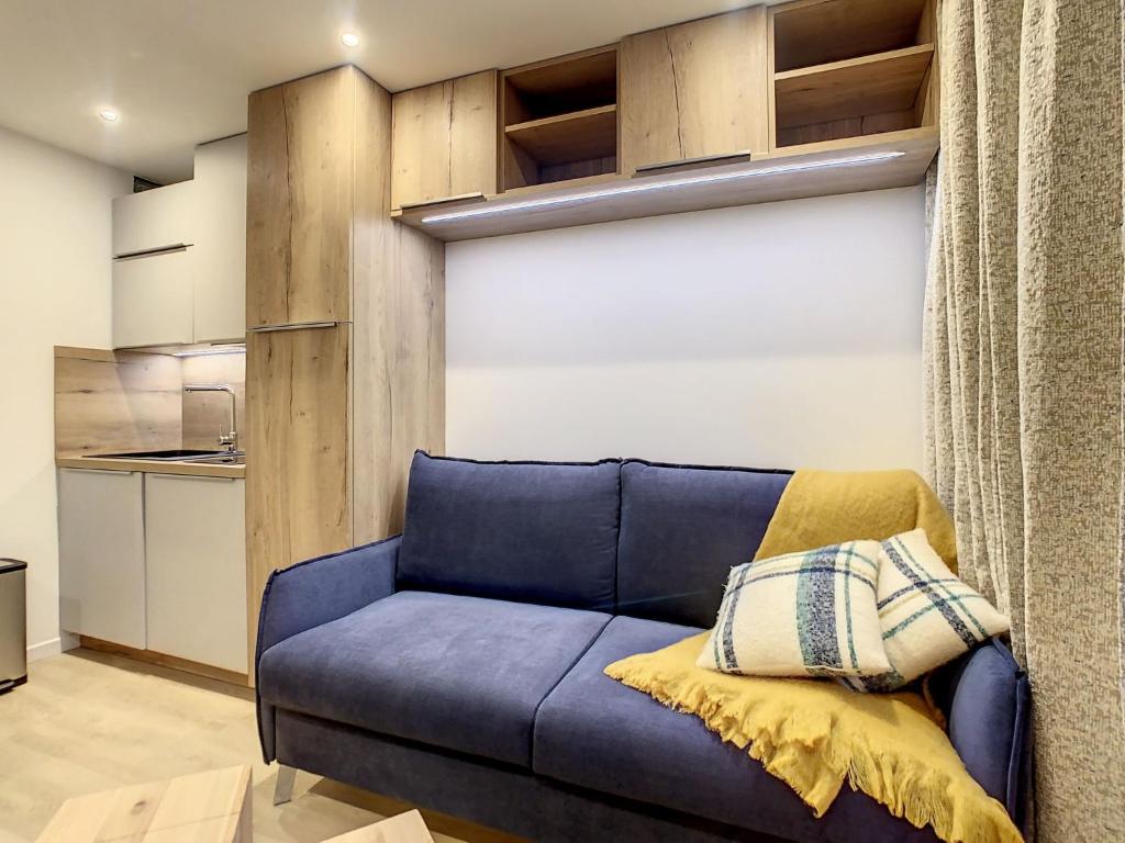 里蒙纽耶Apartment Chavière-12 by Interhome的带厨房的客房内的蓝色沙发