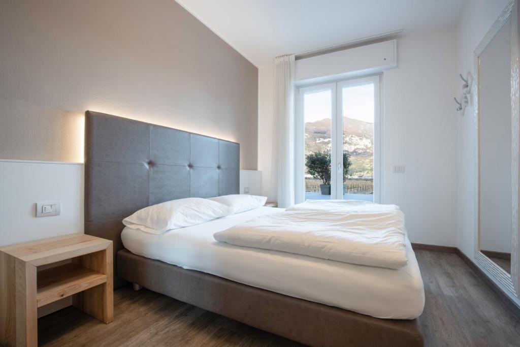 加尔达湖滨洛丽酒店的一间卧室设有一张大床和大窗户
